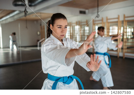 Women practicing karate kata in martial arts studio. Women practicing karate kata in martial arts studio. 142807580