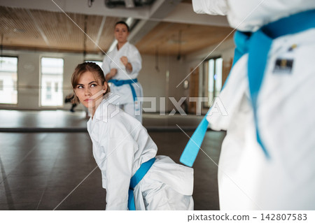 Women practicing karate kata in martial arts studio. Women practicing karate kata in martial arts studio. 142807583