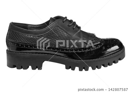 Black patent textured leather women brogue oxford shoes with kiltie fringe on lug sole isolated on white Black patent textured leather women brogue oxford shoes with kiltie fringe on lug sole isolated on white 142807587
