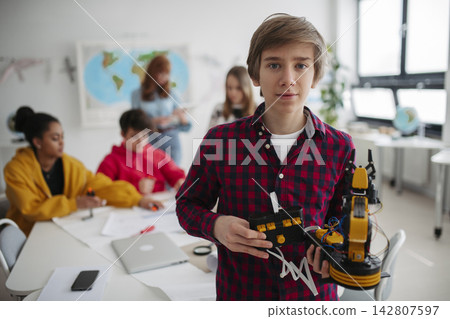 Teen boy explaining robotics project during science and technology class. Teen boy explaining robotics project during science and technology class. 142807597
