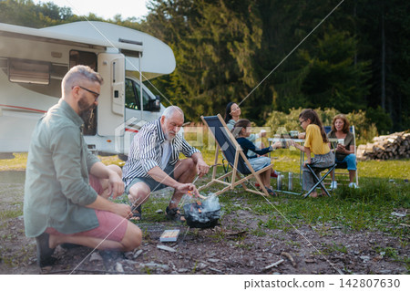 Multigenerational family having picnic dinner during summer caravan vacation. Multigenerational family having picnic dinner during summer caravan vacation. 142807630