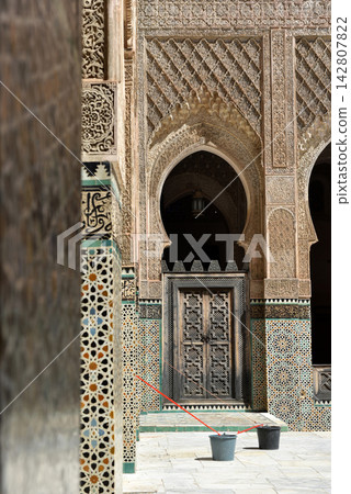 Carved stone gate arch, carved wooden architectural details, Medersa bou Inania, Fez, Morocco Carved stone gate arch, carved wooden architectural details, Medersa bou Inania, Fez, Morocco 142807822
