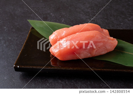 A close-up of a black table and cod roe. A close-up of a black table and cod roe. 142808554