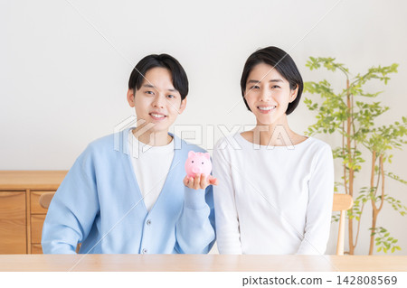 A piggy bank and a married couple A piggy bank and a married couple 142808569