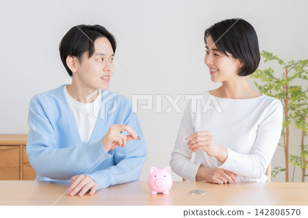 A piggy bank and a married couple A piggy bank and a married couple 142808570