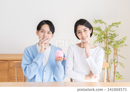 A piggy bank and a married couple A piggy bank and a married couple 142808571