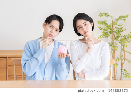 A piggy bank and a married couple A piggy bank and a married couple 142808573