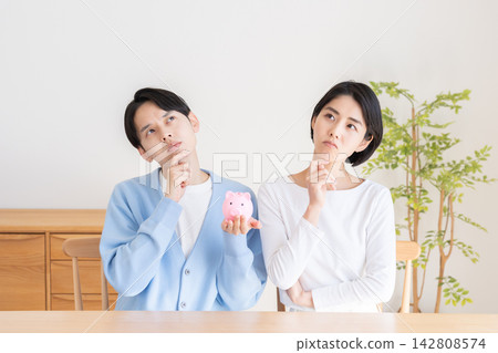 A piggy bank and a married couple A piggy bank and a married couple 142808574