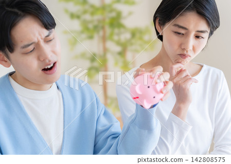 A piggy bank and a married couple A piggy bank and a married couple 142808575