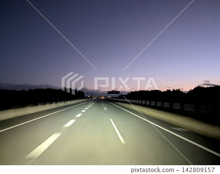 暮色籠罩下,一條高速公路筆直地向前延伸。 暮色籠罩下,一條高速公路筆直地向前延伸。 142809157