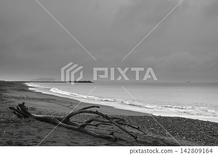 一幅單色風景：雨後海岸線上，雲朵、波光粼粼的海浪，以及朦朧的江之島景色。 142809164