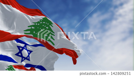 Flags of Israel and Lebanon waving in the wind on a clear day Flags of Israel and Lebanon waving in the wind on a clear day 142809251