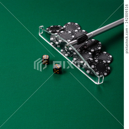 Dice and chips on a green felt gaming table, a poker game in a casino. Casino dice Dice and chips on a green felt gaming table, a poker game in a casino. Casino dice 142809316