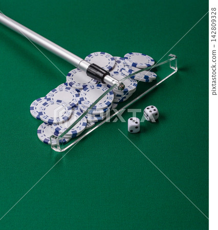 Dice and chips on a green felt gaming table, a poker game in a casino. Casino dice Dice and chips on a green felt gaming table, a poker game in a casino. Casino dice 142809328