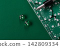 Dice and chips on a green felt gaming table, a poker game in a casino. Casino dice 142809334
