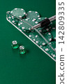 Dice and chips on a green felt gaming table, a poker game in a casino. Casino dice 142809335