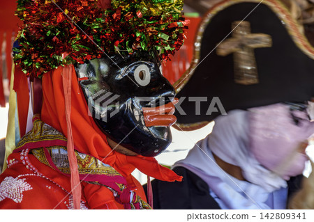 Person wearing a mask from the Folia de Reis 142809341
