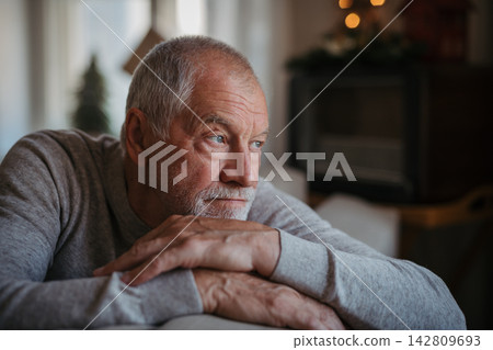 Lonely senior man spending Christmas alone at home without his family. Lonely senior man spending Christmas alone at home without his family. 142809693