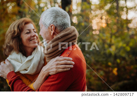 Senior couple enjoying autumn walk in forest. 142809717