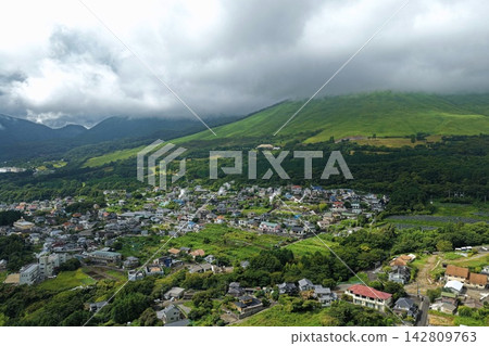 An aerial photograph capturing a mountainous residential area and rising steam from hot springs in Beppu City, Oita Prefecture. An aerial photograph capturing a mountainous residential area and rising steam from hot springs in Beppu City, Oita Prefecture. 142809763