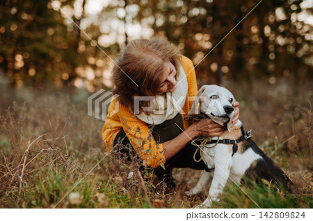 Senior couple walking dog in autumn forest. Senior couple walking dog in autumn forest. 142809824