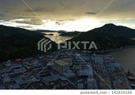 這是一張日落時分從空中拍攝的愛媛縣宇和島市海灣和水產養殖筏的照片。 這是一張日落時分從空中拍攝的愛媛縣宇和島市海灣和水產養殖筏的照片。 142810184