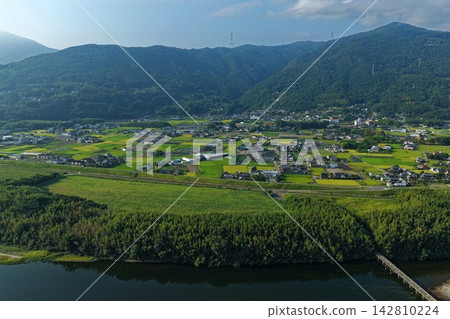 Aerial photograph capturing the Yoshino River, rice paddies, and settlements in Mima City, Tokushima Prefecture. 142810224