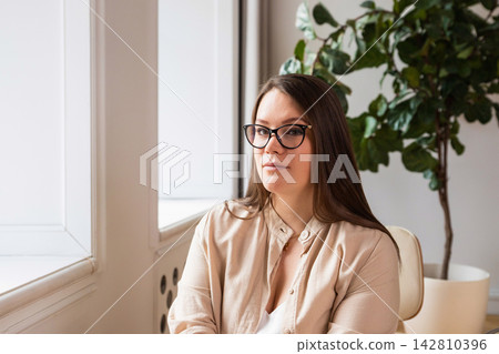 Portrait of a body-positive woman. businesswoman with glasses in the office or psychologist. Portrait of a body-positive woman. businesswoman with glasses in the office or psychologist. 142810396