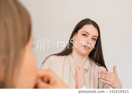 Woman psychologist talking to client during therapy session. Professional consultant giving advice to patient. Mental health care, counseling, communication and conversation concept. Woman psychologist talking to client during therapy session. Professional consultant giving advice to patient. Mental health care, counseling, communication and conversation concept. 142810421