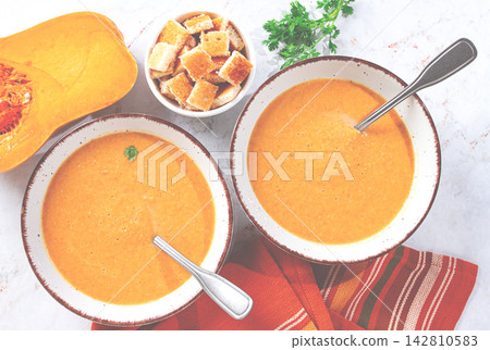 two bowls of pumpkin soup, on the table, with a bowl of toast, top view, no people, two bowls of pumpkin soup, on the table, with a bowl of toast, top view, no people, 142810583