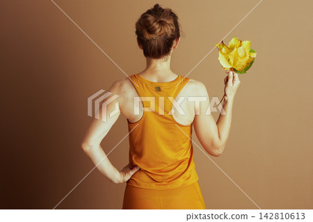 Back View of Athletic Woman with Autumn Leaves Back View of Athletic Woman with Autumn Leaves 142810613