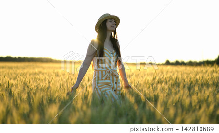 woman walking in a field with open arms 142810689