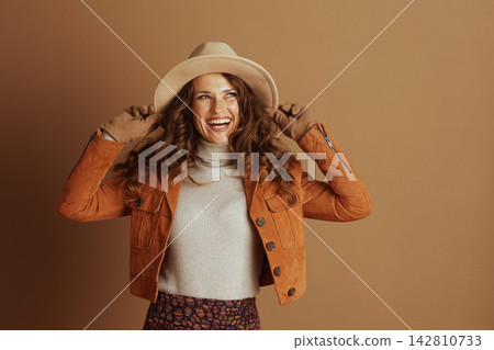 Joyful Woman in Autumn Fashion Holding Hat Joyful Woman in Autumn Fashion Holding Hat 142810733
