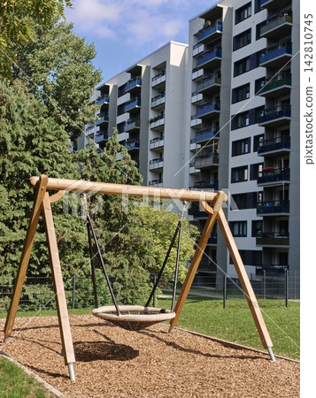 Wooden nest swing at the playground in the courtyard. Wooden nest swing at the playground in the courtyard. 142810745
