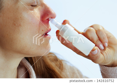 Woman Using Nasal Spray for Sinus Congestion Woman Using Nasal Spray for Sinus Congestion 142810752