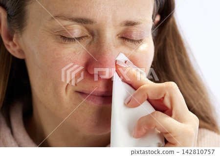 Woman Managing Cold Symptoms with Tissue Woman Managing Cold Symptoms with Tissue 142810757