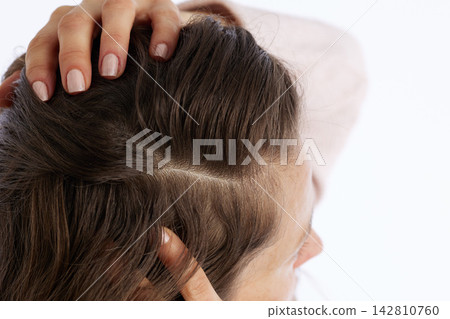 Side View of Hand Touching Dark Hair and Scalp Side View of Hand Touching Dark Hair and Scalp 142810760