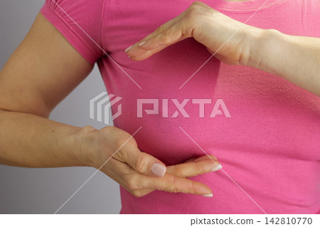 Close-up of Breast Self-Check Gesture in Pink Shirt Close-up of Breast Self-Check Gesture in Pink Shirt 142810770