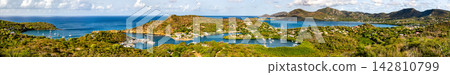 Panoramic view of sailboats docked in English Harbour and the surrounding green hills of Nelson's Dockyard National Park in Antigua. Panoramic view of sailboats docked in English Harbour and the surrounding green hills of Nelson's Dockyard National Park in Antigua. 142810799