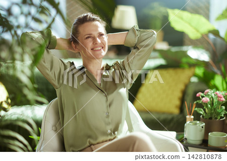 Content Woman Enjoying a Mindful Break with Tea and Plants 142810878