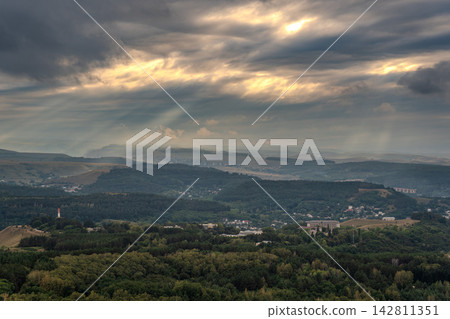 View of the mountains and Kislovodsk from the observation decks of the Kislovodsk Park. Evening sunset over the mountains of Kislovodsk. View of the mountains and Kislovodsk from the observation decks of the Kislovodsk Park. Evening sunset over the mountains of Kislovodsk. 142811351