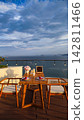 Rooftop Cafe Wooden Table and Chairs with Scenic Ocean View and Partly Cloudy Sky 142811466