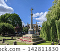 A stone monument standing in a Cotswolds village. 142811830