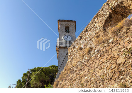Historic clock tower beside stone walls Cannes. Historic clock tower beside stone walls Cannes. 142811923