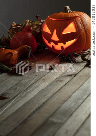 Halloween pumpkin head jack lantern with dried-up leaves. Halloween pumpkin head jack lantern with dried-up leaves. 142812032