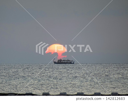 一艘船航行在海上,以落日為背景。 一艘船航行在海上,以落日為背景。 142812683
