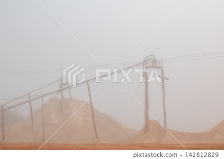 Details of a sand mining operation amidst winter fog, creating a fantastic landscape in Brazil; selective focus. 142812829
