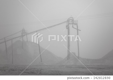 Details of a sand mining operation amidst winter fog, creating a fantastic landscape in Brazil; selective focus. Details of a sand mining operation amidst winter fog, creating a fantastic landscape in Brazil; selective focus. 142812830