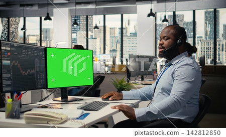Trader chatting with customer, providing tailored financial strategy using chroma key computer. Financial advisor talking in headset mic, using isolated screen PC, reviewing client portfolio Trader chatting with customer, providing tailored financial strategy using chroma key computer. Financial advisor talking in headset mic, using isolated screen PC, reviewing client portfolio 142812850