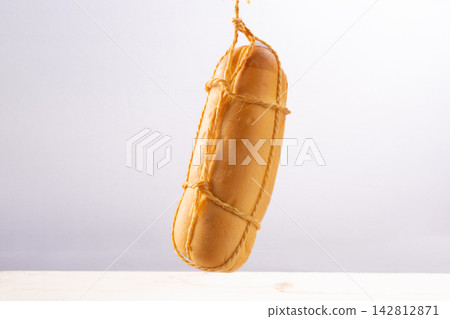 Provolone cheese, some smoked provolone cheeses made in Brazil hanging from ropes, white background, selective focus. 142812871